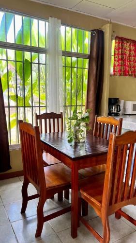 a dining room table and chairs with a table and windows at Blue House with Air-Conditioning in Puerto Jiménez