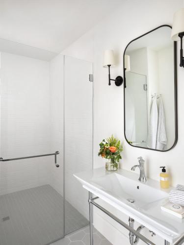 a white bathroom with a sink and a mirror at 1313 West Luxury Boutique Hotel in Annapolis