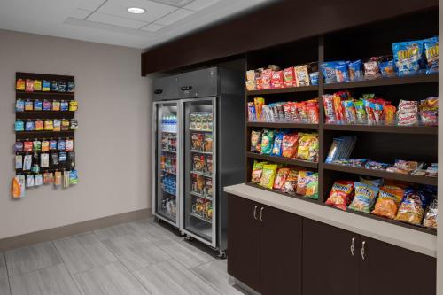 a store aisle with a refrigerator and shelves of food at Holiday Inn Express & Suites Midland Loop 250 by IHG in Midland