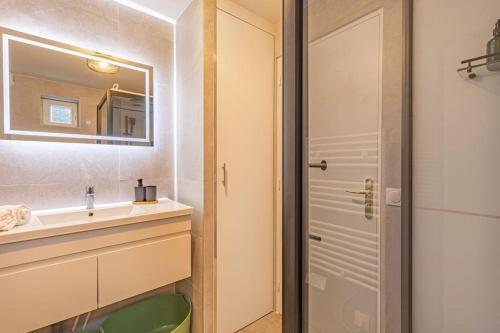 une salle de bain avec un lavabo et un miroir dans l'établissement Maison paisible T3 à 20min de Paris, à Vitry-sur-Seine
