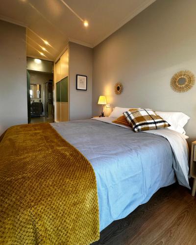 a bedroom with a large bed with a blue blanket at Apartamento Miracies in Vigo