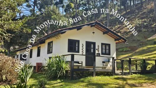 a small white house with a hill in the background at ACasA in Gonçalves