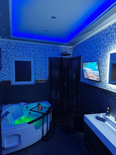 a bathroom with a tub and a tv on the wall at Luxus Loft Whirlpool Designer Küche Bad in Herdecke
