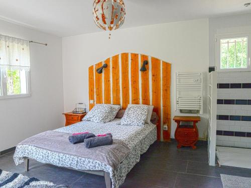 een slaapkamer met een groot bed met een houten hoofdeinde bij Les Dourets in Saint Antonin du Var
