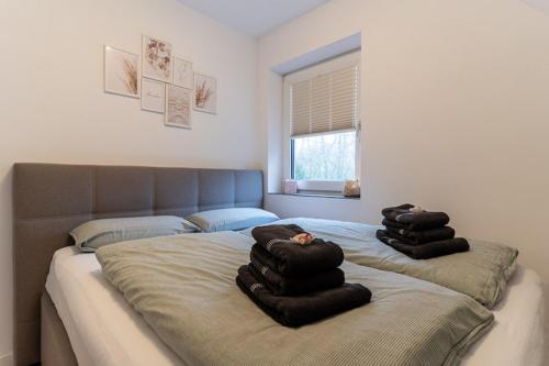 a bedroom with two beds with black towels on them at Ferienwohnung in St Peter-Ording in St. Peter-Ording