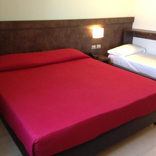 a bedroom with two beds with a red bedspread at Blu Arena Hotel in Montecchio