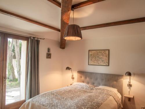 a bedroom with a bed and a window at Le Mas Romarin in Beaumes-de-Venise