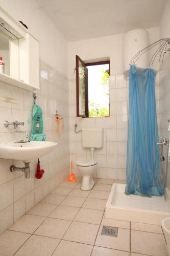 a bathroom with a toilet and a sink and a window at Apartments by the sea Zaglav, Dugi otok - 8134 in Sali
