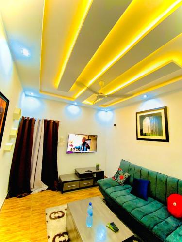 a living room with a green couch and a tv at Smart Residences Apart Go in Cotonou