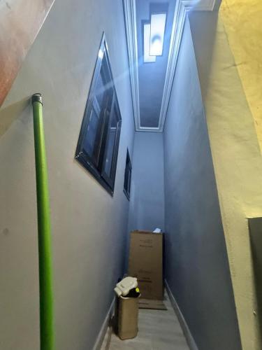 a hallway with a green pole and a wall with windows at Smart Residences Apart Go in Cotonou
