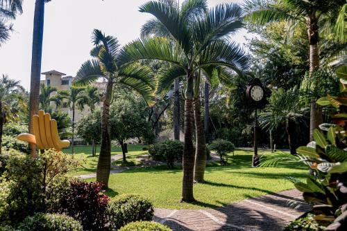 a park with palm trees and a clock in it at Holiday Inn Cuernavaca by IHG in Cuernavaca