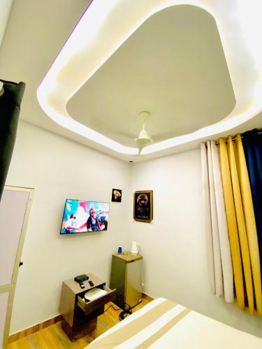 a room with a ceiling with a tv on the wall at Smart Residences Apart Go in Cotonou