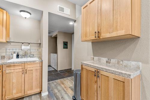 a kitchen with wooden cabinets and a sink at Charming Country Club Condo with Loft & Fireplace in Flagstaff
