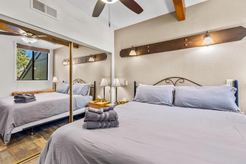 a bedroom with two beds and a ceiling fan at Charming Country Club Condo with Loft & Fireplace in Flagstaff