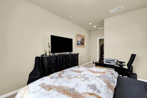 a bedroom with a bed and a flat screen tv at 1 Mi to Dtwn Winters Home with Fire Pit and Patio! in Winters