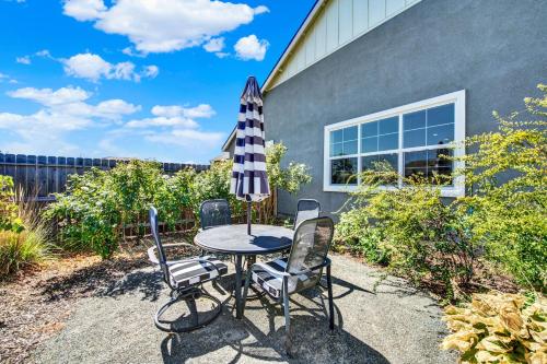 a patio table with four chairs and an umbrella at 1 Mi to Dtwn Winters Home with Fire Pit and Patio! in Winters