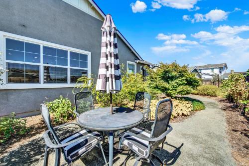 a table and chairs with an umbrella in front of a house at 1 Mi to Dtwn Winters Home with Fire Pit and Patio! in Winters