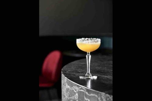 a drink in a glass sitting on a table at Midnight Luxe 2BR 2Bath 2Car 230 Pool Gym Sauna in Canberra