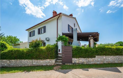a white house with a stone wall at Six-Bedroom Holiday Home In Barban in Barban