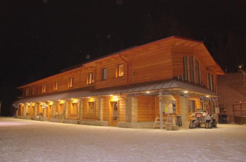 a large wooden building in the snow at night at Ubytování Skipot in Potŭčky