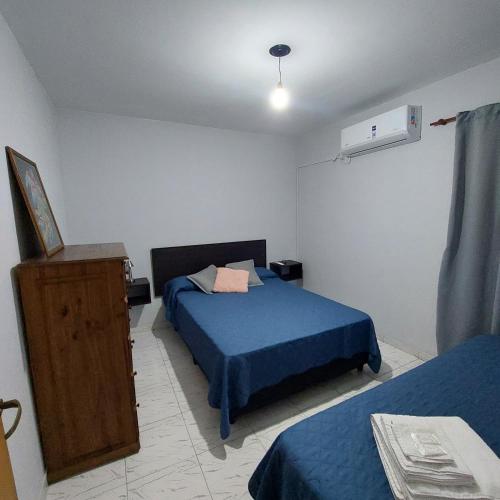 a bedroom with two beds and a dresser in it at Departamentos Falucho 3 in Santa Rosa