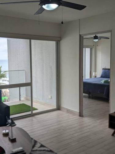 a living room with a bed and a ceiling fan at White Sands, Aquamarine waters and High Surfs in Punta Chame