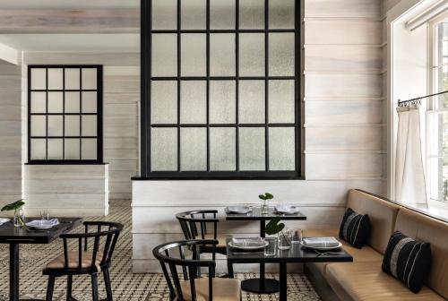 a dining room with two tables and chairs at Kimpton Brice Hotel by IHG in Savannah