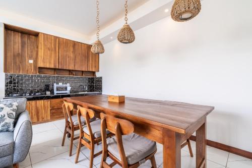 a kitchen with a wooden table and chairs at Akasia Hill Villas in Nusa Dua