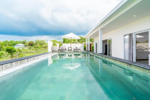 a swimming pool with blue water in a house at Akasia Hill Villas in Nusa Dua