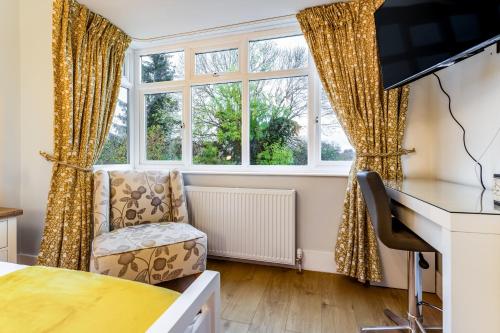 a bedroom with a desk and a chair in front of a window at Greenview double bedroom 5 in Oxford