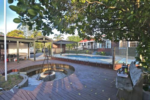 a backyard with a swimming pool and a tree at Holiday house in totara park in Auckland