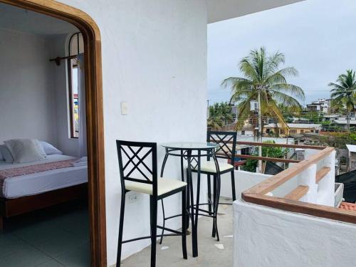 Una habitación con balcón con mesa y sillas. en Suite con acceso a terraza vista a la Bahia, en Puerto Ayora