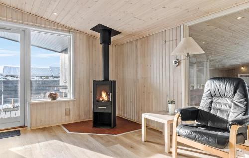 a living room with a fireplace and a chair at Gorgeous Home In Thisted With Sauna in Klitmøller