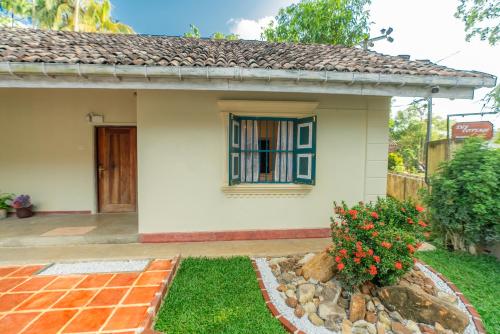 a small house with a window and a yard at Ivy Cottage in Ahangama