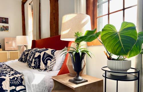 a bedroom with a bed and two plants on a table at Osceola Mill in Raphine