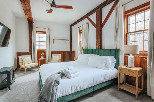 a bedroom with a white bed with a green headboard at Osceola Mill in Raphine