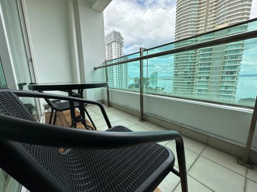 a balcony with two chairs and a table and a window at 10pax 3-Bedroom l Seaview l Georgetown l Gleneagles l Mansion One in George Town