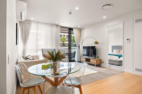 a dining room and living room with a glass table and chairs at Waterfront luxury living - Wynyard Quarter in Auckland