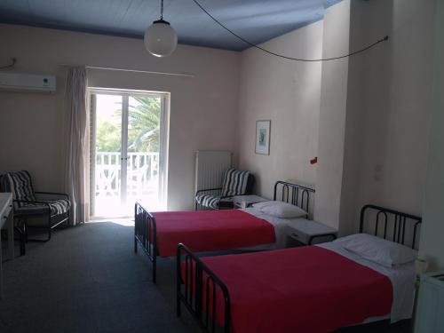 a hotel room with two beds and a window at Hotel Cavo Mytikas in Mitika