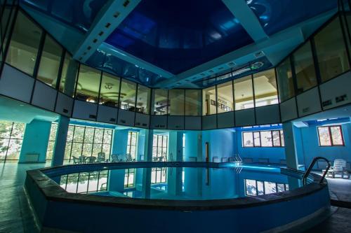 an indoor swimming pool in a building with blue ceilings at Arzni Health Resort in Arzni