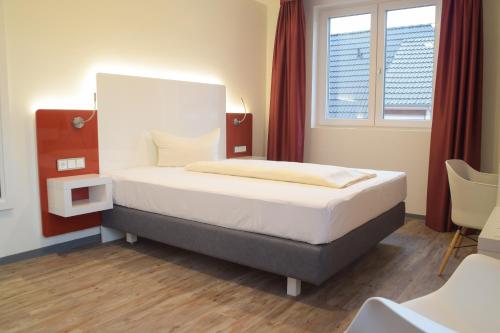 a bedroom with a bed and a window at Hotel Arts in Sankt Leon-Rot
