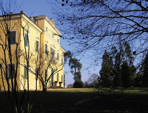 a large yellow building with trees in front of it at Fattoria Grimana in Montegalda