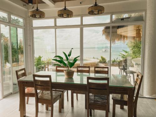 a dining room with a table and chairs and a large window at Avila's Horizon Dive Resort Santander in Santander