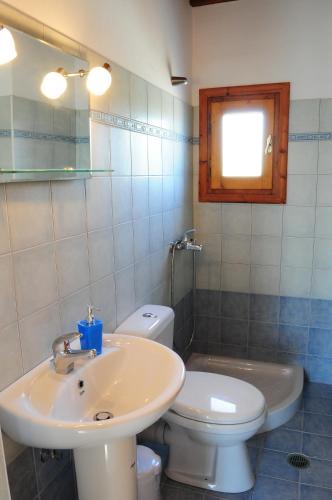 a bathroom with a sink and a toilet and a window at Ariadne House in Agia Anna Naxos
