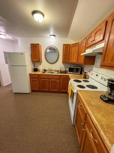 a kitchen with wooden cabinets and a white refrigerator at Cozy Retreat Near Ft Wood! in Waynesville