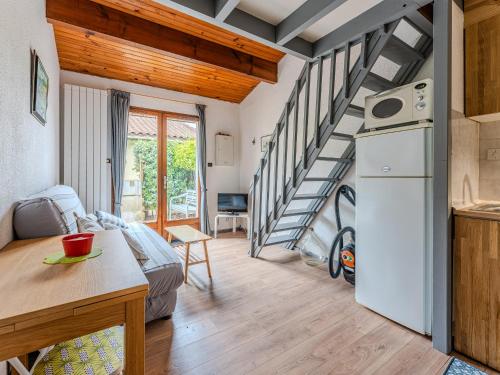 une chambre avec un lit et une cuisine avec un escalier en colimaçon dans l'établissement Maison mitoyenne 300m de la plage avec cour et parking - 4 pers, Non Fumeur - FR-1-521-242, à Biscarrosse