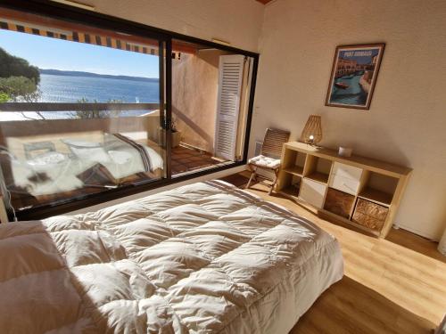 un grand lit dans une chambre avec une grande fenêtre dans l'établissement Appartement 4 pièces avec piscine et garage à Sainte-Maxime - FR-1-780-44, à Sainte-Maxime