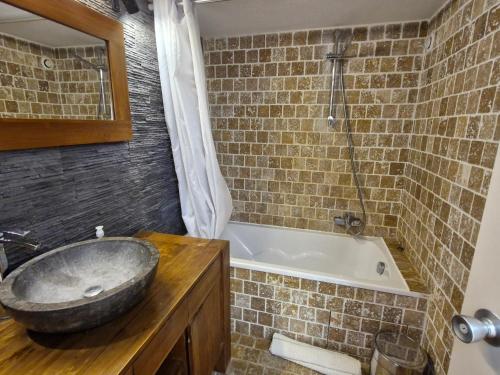 La salle de bains est pourvue d'un lavabo en pierre et d'une baignoire. dans l'établissement Appartement 4 pièces avec piscine et garage à Sainte-Maxime - FR-1-780-44, à Sainte-Maxime