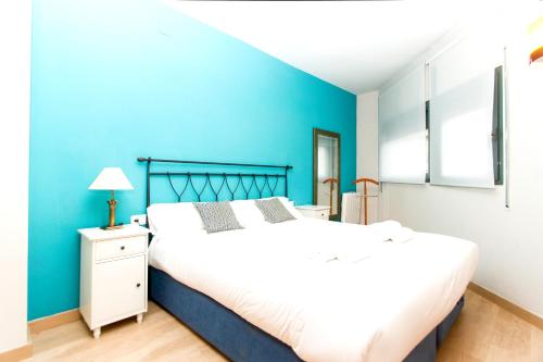 - une chambre avec des murs bleus et un grand lit dans l'établissement Apartment Bright Sagrada Familia, à Barcelone