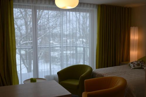 een slaapkamer met een bed, een raam en een stoel bij Aisa 39 Külaliskorter in Pärnu